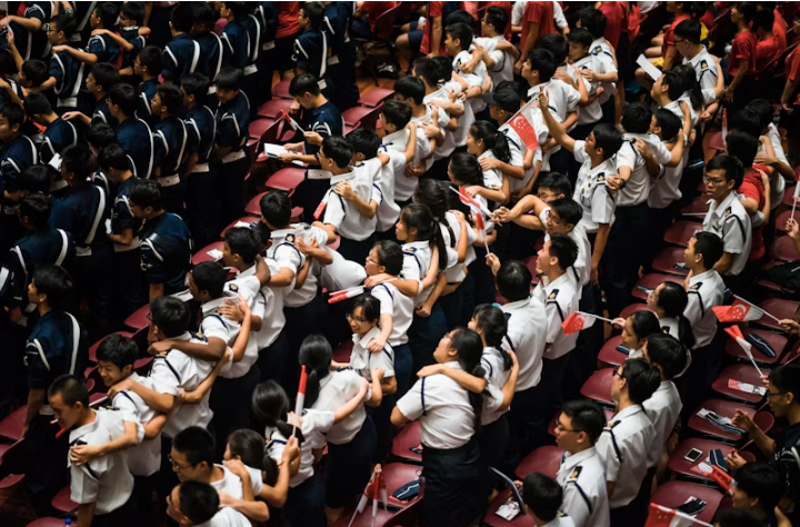 Singapore students holding Singaporean flag. 5 countries with the lowest proof of funds for student visas.